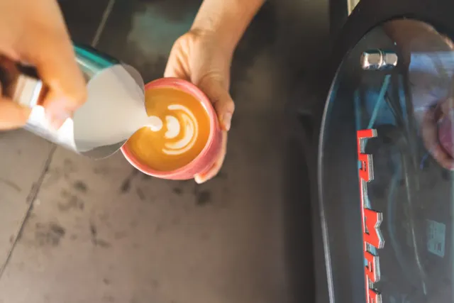 A flat white being poured at Holiday Coffee