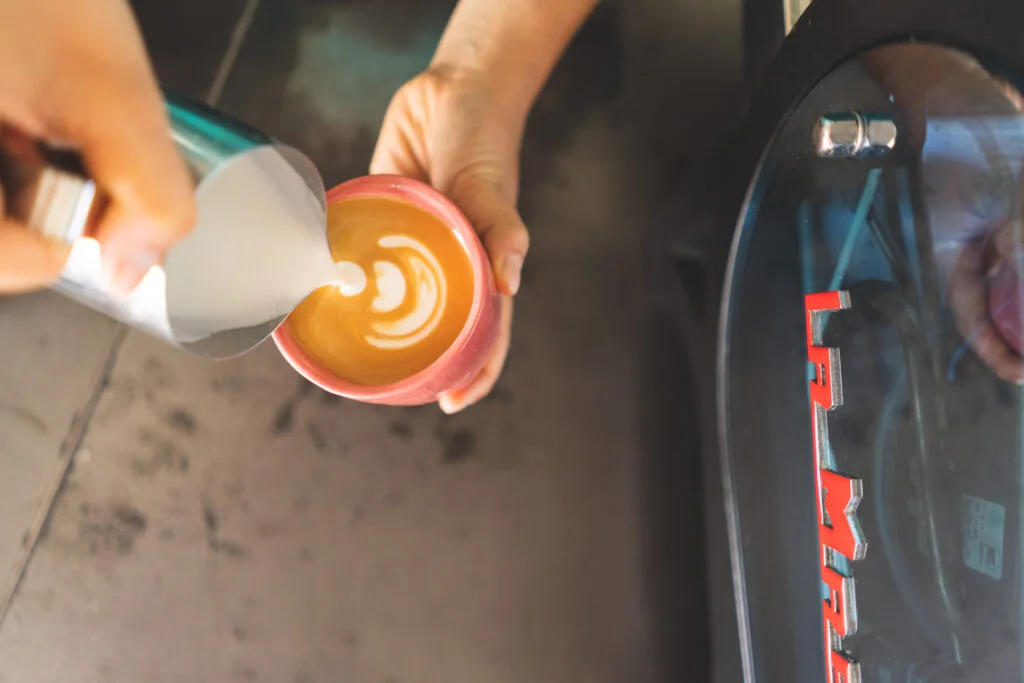 A flat white being poured at Holiday Coffee