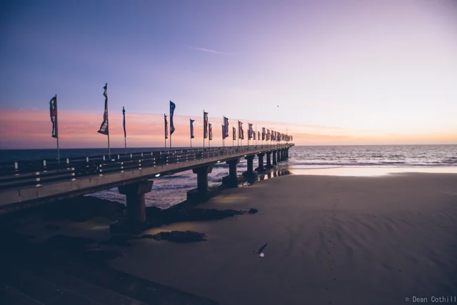 Flags along Shark Rock Pier in the early morning light